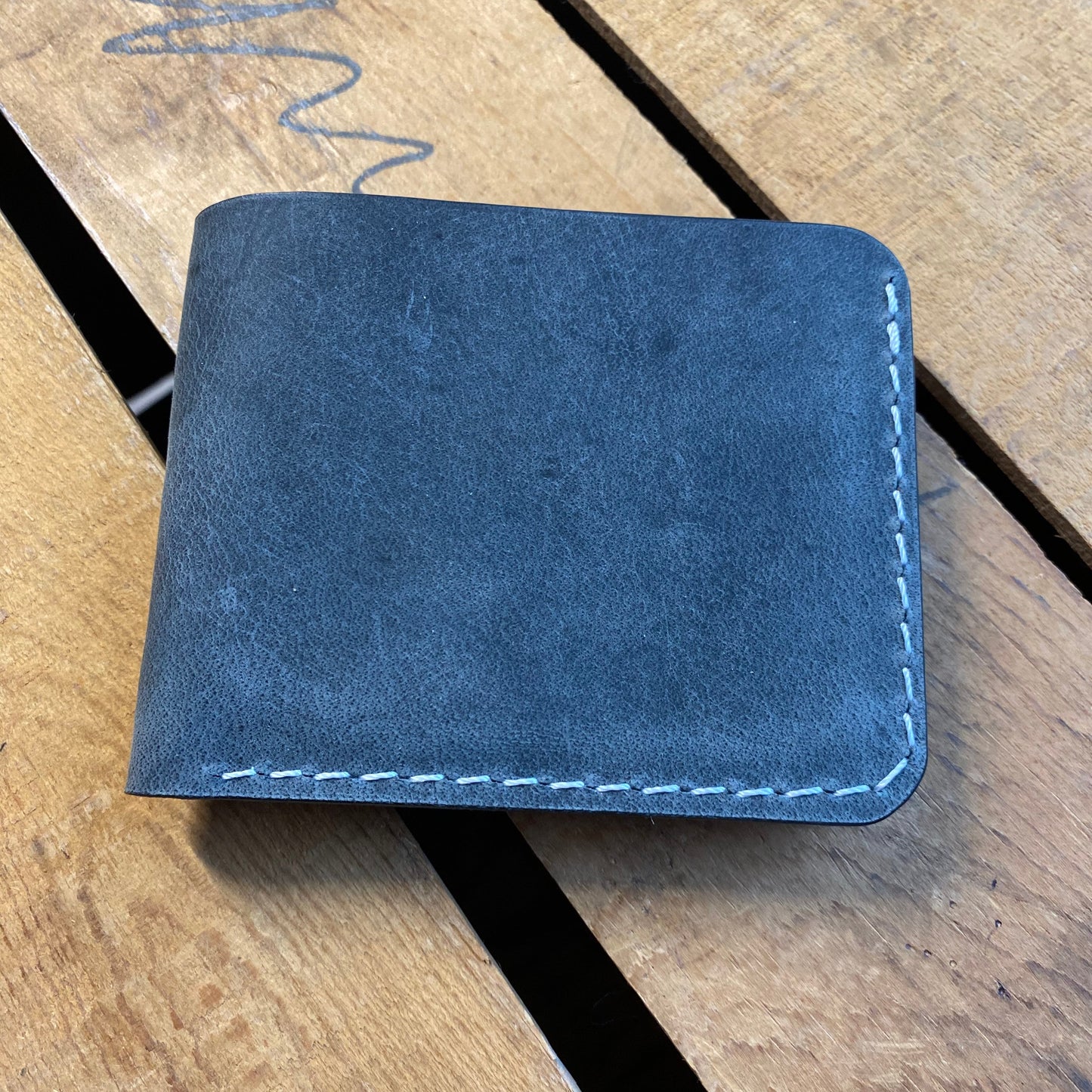 Blue leather wallet on a wooden surface